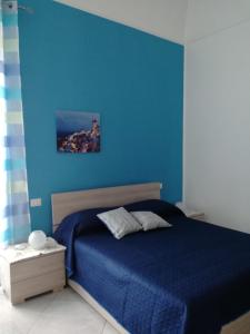 a blue bedroom with a bed with a blue wall at Dalla Maestra Lucia in Procida