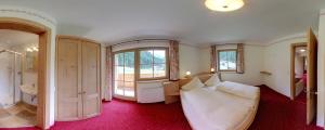 a large room with a bed and a bathroom at Landhaus Wildes Wasser in Neustift im Stubaital