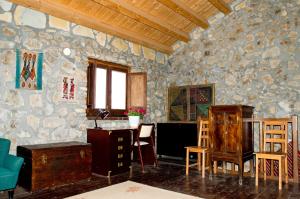 Habitación con pared de piedra, mesa y sillas. en Casa Batia, en Cefalú