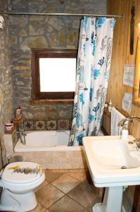 a bathroom with a tub and a toilet and a sink at Casa Batia in Cefalù