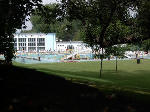 a park with a swimming pool in front of a building at Dobre ubytovanie in Piešťany