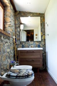 a stone bathroom with a sink and a toilet at Casa Batia in Cefalù