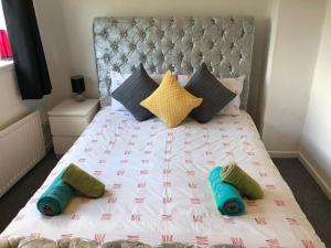 a bed with four pillows on top of it at Cosy house near Edinburgh and St Andrew's in Kirkcaldy