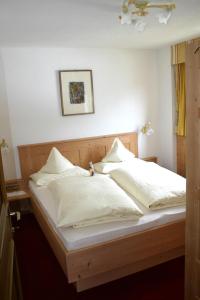 łóżko z białą pościelą i poduszkami w obiekcie Waldheim w mieście Solda