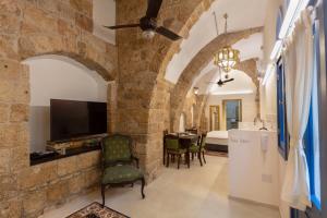 a living room with a tv in a stone wall at Alma in ‘Akko