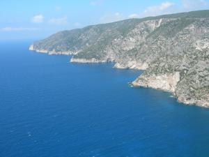 an aerial view of a large body of water between cliffs at STERNES house in Agios Leon