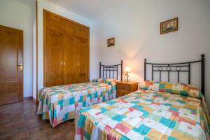 sypialnia z dwoma łóżkami i drewnianymi drzwiami w obiekcie Chalet Miriam II w mieście Conil de la Frontera