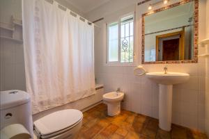 łazienka z toaletą, umywalką i lustrem w obiekcie Chalet Miriam II w mieście Conil de la Frontera +3 zdjęcia
