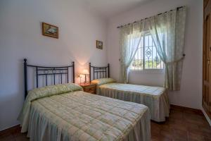 sypialnia z dwoma łóżkami i oknem w obiekcie Chalet Miriam II w mieście Conil de la Frontera