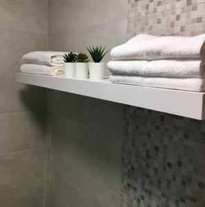 a shelf in a bathroom with towels and plants at Appartement Miramar in Mohammedia