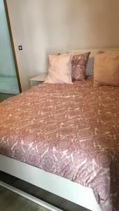 a large bed in a room with a bedspread at Appartement Miramar in Mohammedia +30 photos