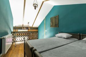 um quarto com 2 camas e uma parede azul em 3 Heritage Rooms em Tbilisi