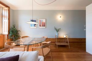 jadalnia ze szklanym stołem i krzesłami w obiekcie Cardosas Palace Apartment w Porto