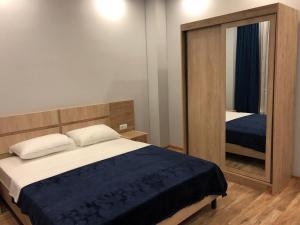 ein Schlafzimmer mit einem Bett und einem großen Spiegel in der Unterkunft Hotel Royal Georgia in Batumi