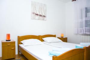 a bedroom with a large bed with white sheets at Apartman GROMILA in Senj