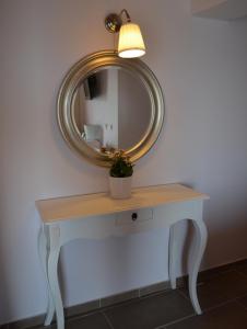 a table with a mirror and a potted plant on it at Romanza Studios in Asos