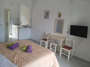 a bedroom with a bed with purple pillows on it at Fotini Studios in Paleokastritsa