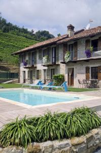 une villa avec une piscine en face d'un bâtiment dans l'établissement Sul Bric Dei Capalot, à La Morra