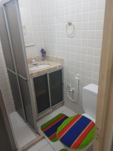 a bathroom with a sink and a toilet and a rug at Pousada Manaíra Buena Playa in João Pessoa +44 photos