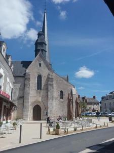 a church with a steeple on the side of a street at LAUBERG;APPART in Cour-Cheverny