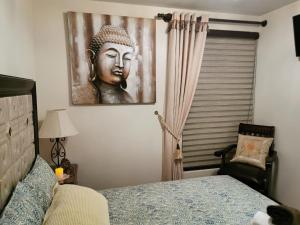 a bedroom with a picture of a buddha on the wall at Acogedor y Elegante Estudio cerca al Prado in Cochabamba