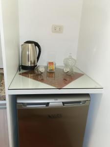 a counter top with a tea kettle on top of a stove at Acogedor y Elegante Estudio cerca al Prado in Cochabamba +17 photos