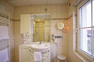 a bathroom with a sink and a mirror at Gästehaus Marietta in Osann-Monzel +31 photos