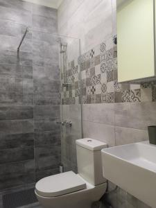 La salle de bains est pourvue de toilettes, d'une douche et d'un lavabo. dans l'établissement Kd's - Apartment, à La Canée