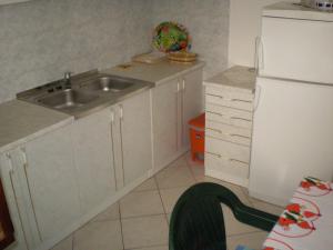 a small kitchen with a sink and a refrigerator at Apartment Smil - 30 m from sea in Sućuraj