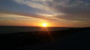 a sunset over the ocean with the sun in the sky at STERNES house in Agios Leon