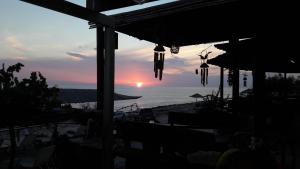 a sunset over the beach with the ocean in the background at STERNES house in Agios Leon