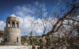 a tower with a cross on top of a building at STERNES house in Agios Leon