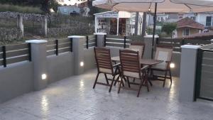 a patio with a table and chairs and an umbrella at STERNES house in Agios Leon