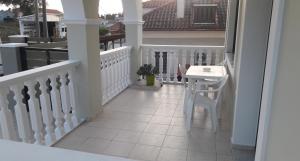 a white balcony with a table and a stool at STERNES house in Agios Leon