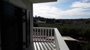 a porch with a white fence and a view of the city at STERNES house in Agios Leon