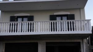 a white balcony on a house with black shutters at STERNES house in Agios Leon