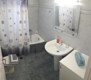 a bathroom with a sink and a toilet and a tub at STERNES house in Agios Leon