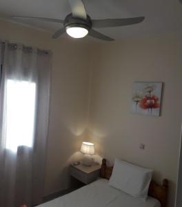 a bedroom with a bed and a ceiling fan at STERNES house in Agios Leon