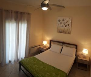 a bedroom with a bed and two tables with lamps at STERNES house in Agios Leon