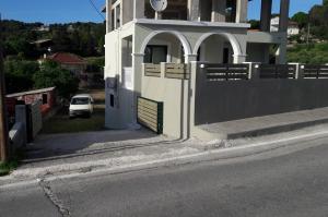 a white car parked next to a building with a gate at STERNES house in Agios Leon