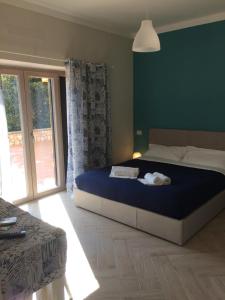 une chambre avec un grand lit et une grande fenêtre dans l'établissement La Villetta Apartments, à Castel Gandolfo