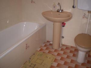 a bathroom with a sink and a tub and a toilet at Apartment Smil - 30 m from sea in Sućuraj