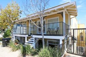 a yellow house with a white deck and a porch at Casa California in San Diego