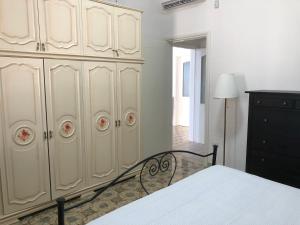 een slaapkamer met een bed en een grote witte kast bij Casa direttamente sul mare 1 in Marina di Mancaversa