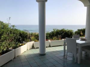 une terrasse avec une table et des chaises et l'océan dans l'établissement Casa direttamente sul mare 1, à Marina di Mancaversa