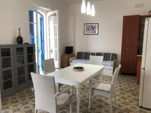 een keuken en een woonkamer met een witte tafel en stoelen bij Casa direttamente sul mare 1 in Marina di Mancaversa