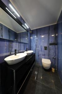a bathroom with two sinks and a toilet in it at Boutique Residence Cosmopolis 1 in Bibinje