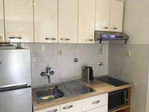 a small kitchen with a sink and a refrigerator at Apartments Jani in Hvar