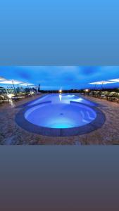 una gran piscina azul con sillas alrededor en Abbaidda Hotel, en Valledoria