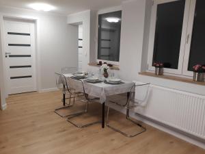 a dining room with a table and chairs in a room at Apartament Reda z prywatną sauną in Reda